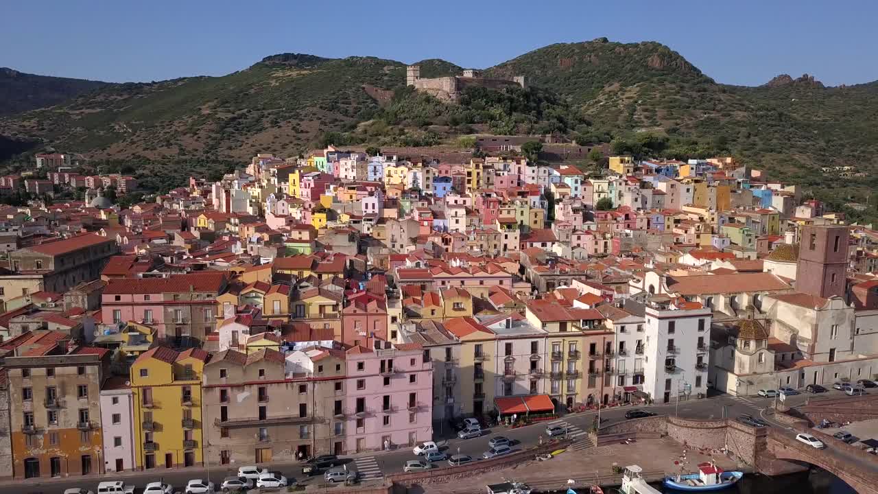 Bosa - Drone aerial shot, point of interest flying over the colourful town of Bosa and the castle on the hill top