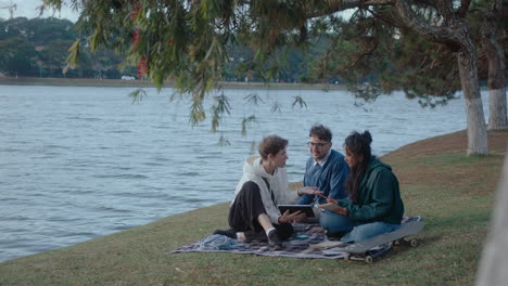 group of students using digital tablet in the park