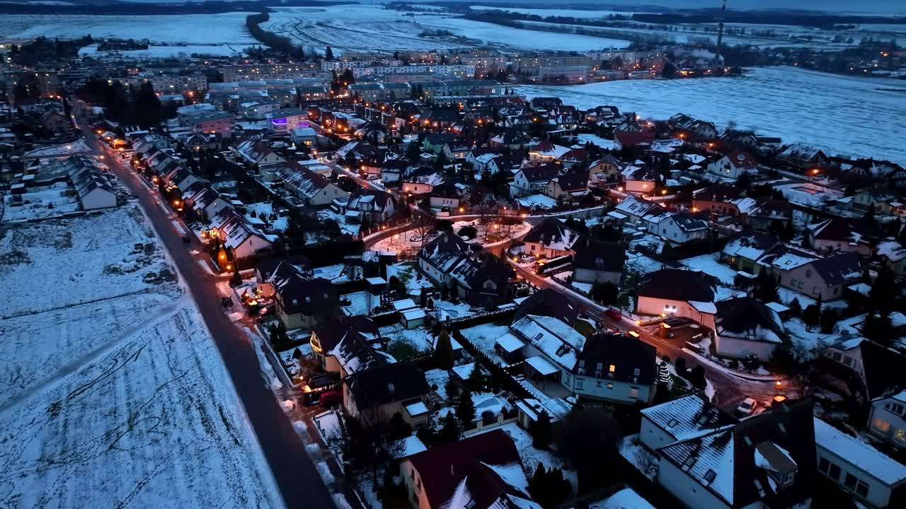 hermoso dron aéreo disparó sobre hileras de casas y caminos cubiertos de nieve en una fría noche de invierno
