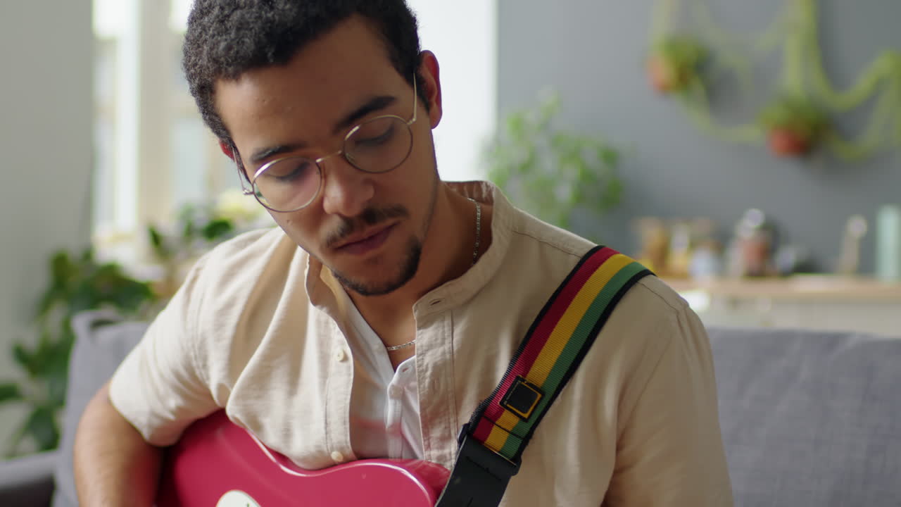 Homem da Geração Z tocando violão em casa