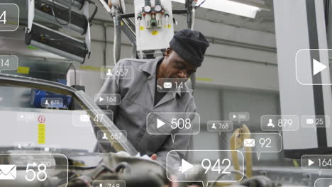 technician examining vehicle frame inside automotive factory, projecting ar media icons and counts