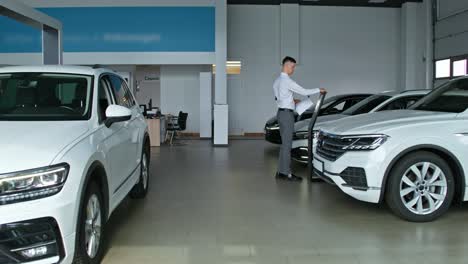 man examining cars in a modern car dealership