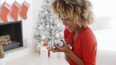 mujer joven que lleva un puñado de adornos navideños