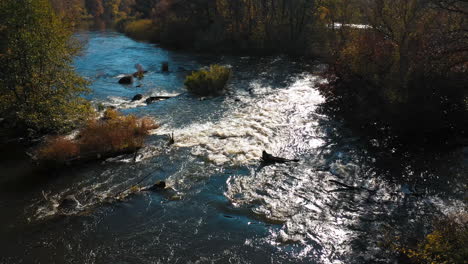wide river is flowing at sunset in the autumn. sun's rays are reflecting in the water of the lake. aerial view