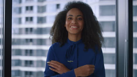 happy african american businesswoman looking camera posing in modern office.