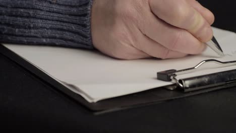 busy person writing up notes on a clipboard close up