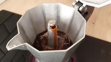 Coffee-pouring-from-small-hole-in-open-stainless-steel-moka-pot-in-slowmotion