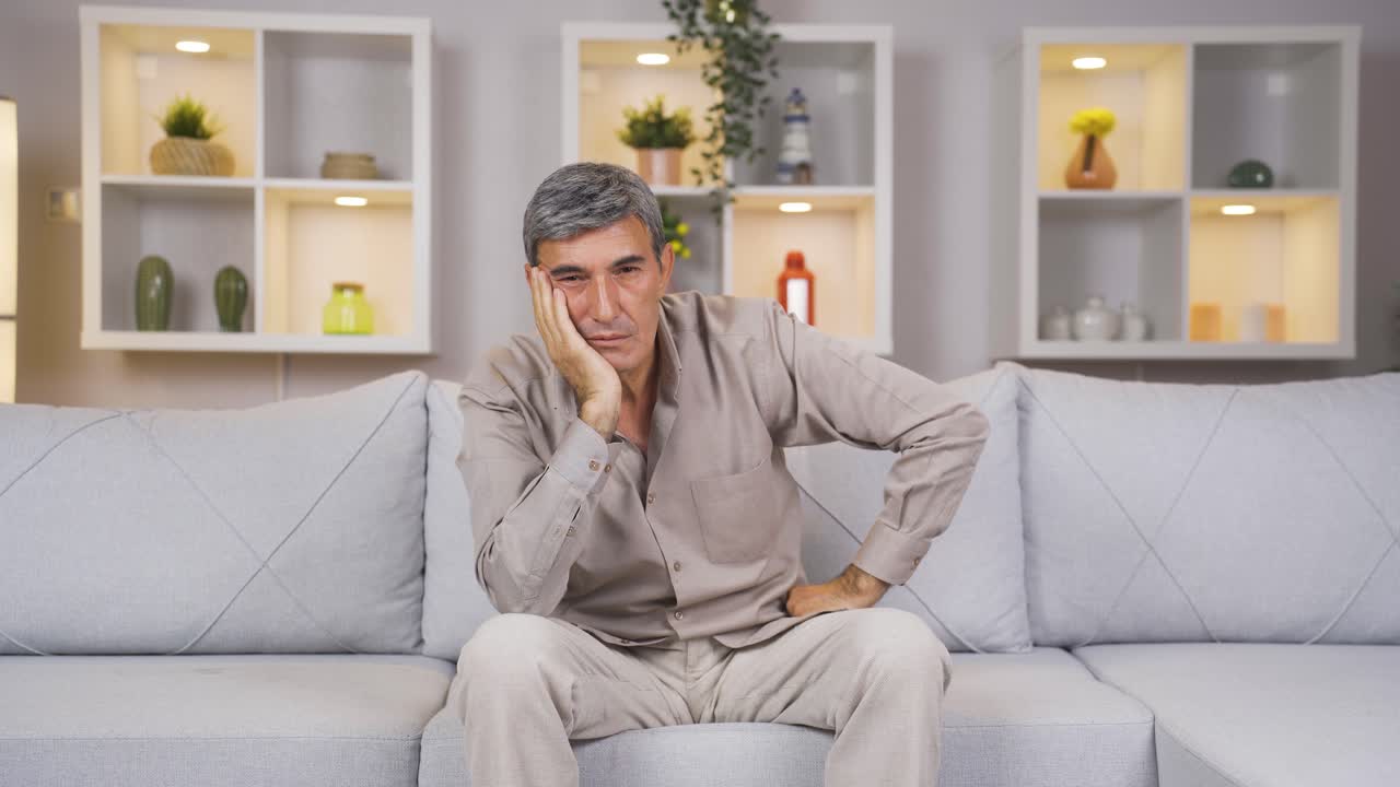 un anciano mirando pensativo a la cámara.