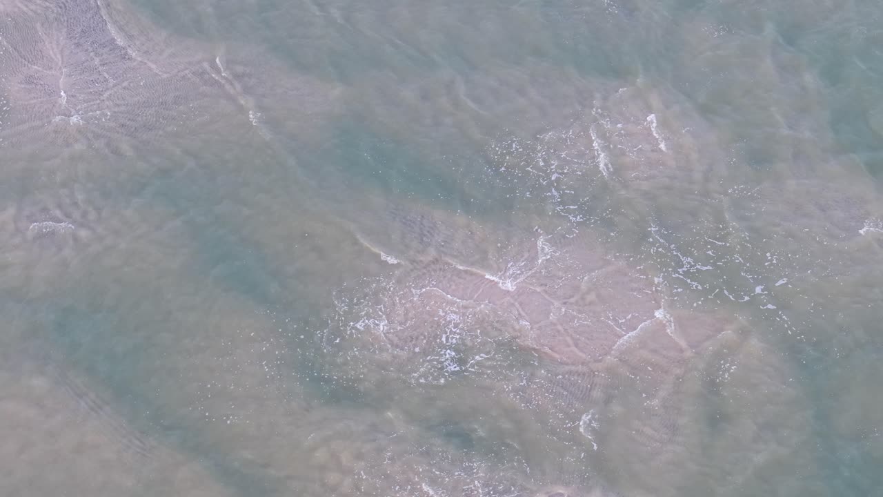Drone shot capturing a top down view of swirling river currents and patterns in murky green water