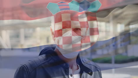 animation of flag of croatia waving over caucasian man wearing face mask in city street