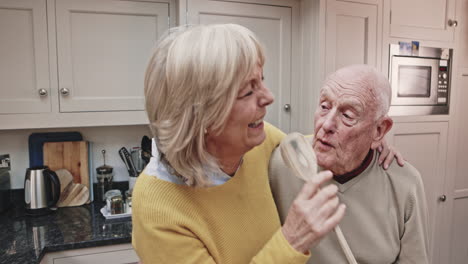 elderly couple having fun in the kitchen
