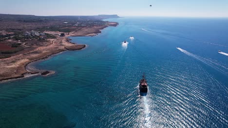 Toma-Real-De-Veleros-Y-Barcos-En-La-Costa-De-Ayia-Napa,-Turista-Black-Pearl-Boatrip-En-Mar-Cristalino