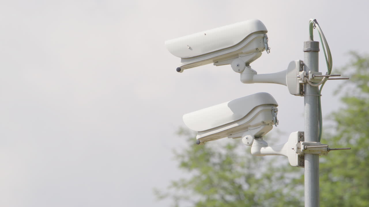 enfoque del estante hacia cámaras de cctv blancas montadas en un poste de metal, primer plano