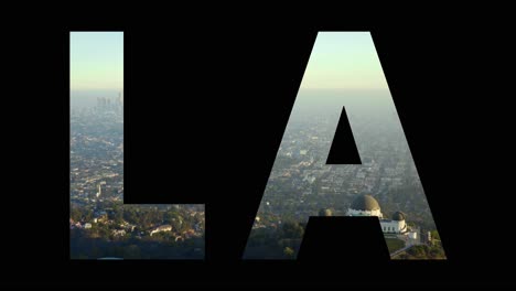 Aerial-Drone-Shot-Of-City-Buildings-And-Skyline-In-America-Overlaid-With-Graphic-Spelling-Out-LA
