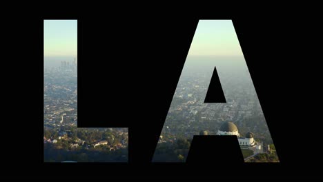 aerial drone shot of city buildings and skyline in america overlaid with graphic spelling out la