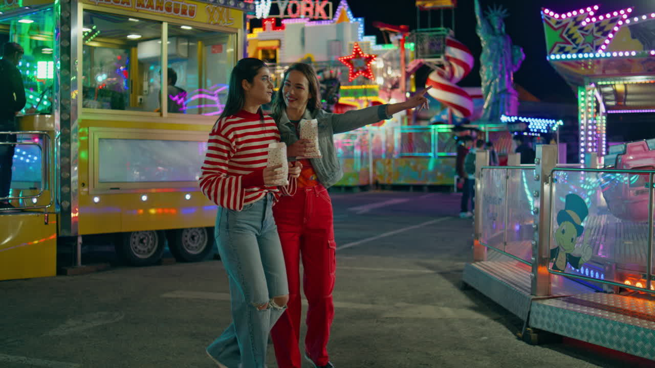 Teenage friends hang out together at amusement luna park. Joyful girls laughing