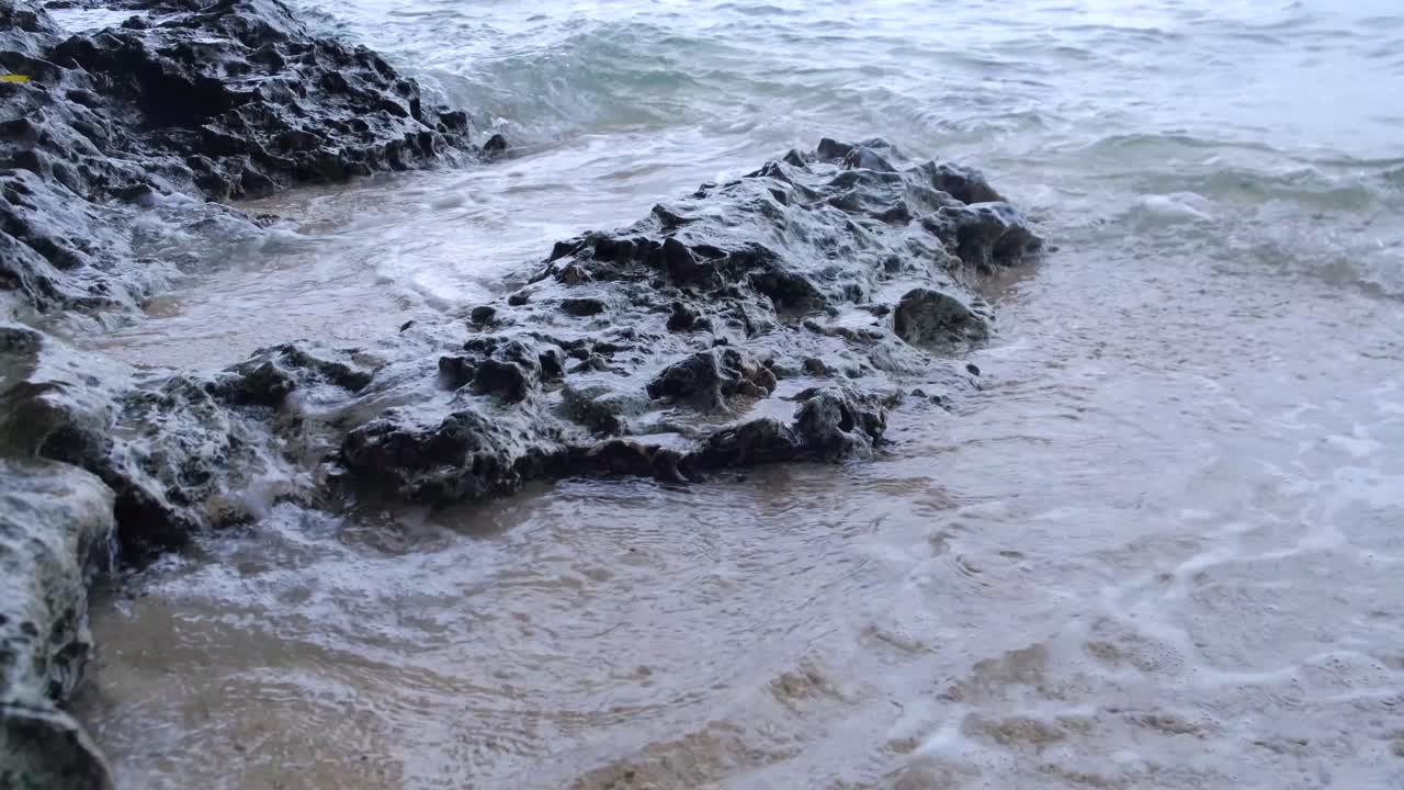 Onde spumeggianti che si infrangono su una costa rocciosa nella città di Aloguinsan a Cebu, Filippine.