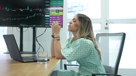 A-distressed-blonde-woman-faces-financial-losses-in-trading-at-her-laptop