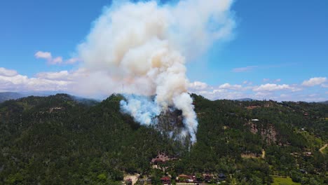 mountain under fire, nature and wildlife destruction by human being, stunning smoke trail in the sky, aerial view of a burning mountain