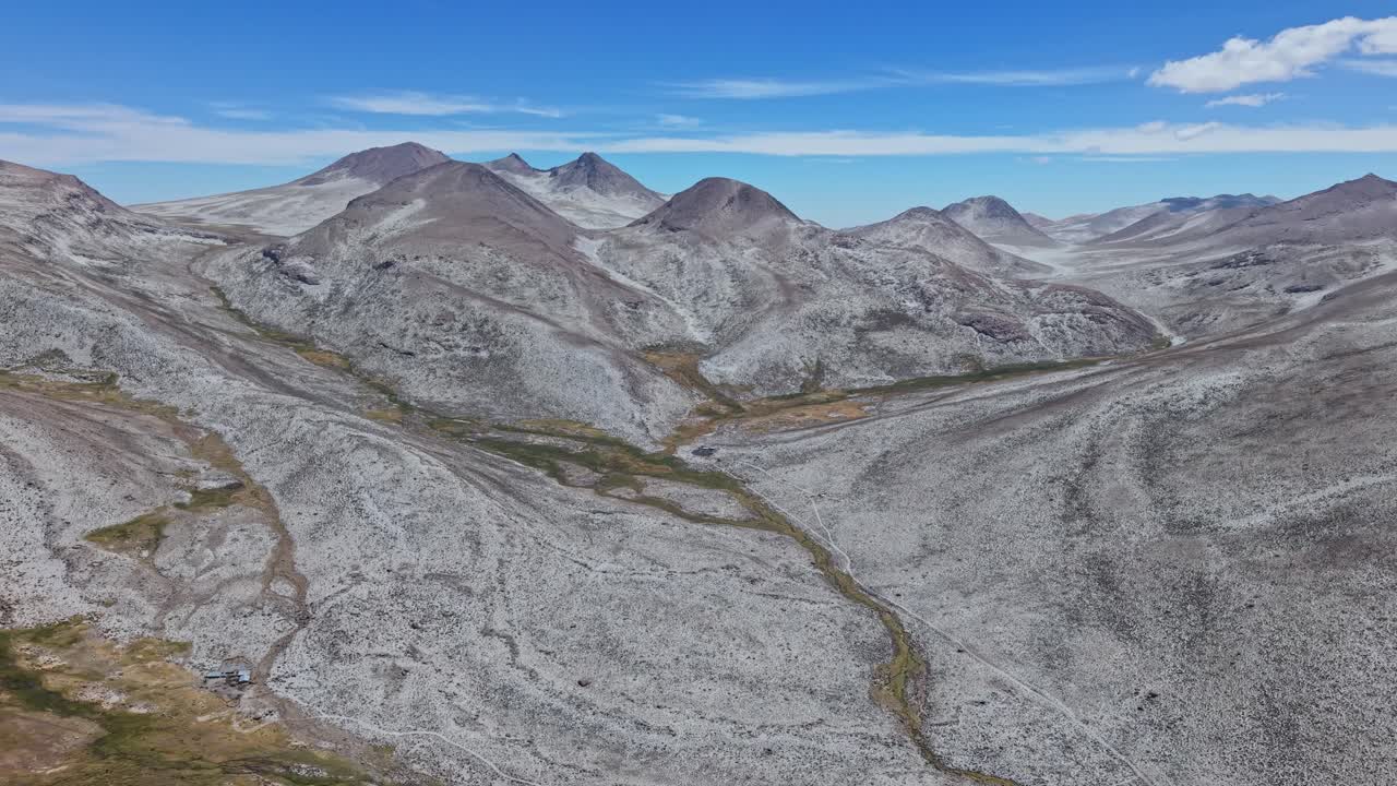 Magisk flygbildspanorering över Qillqatas saltbelagda toppar och omgivande dalar, som avslöjar ett surrealistiskt, drömlikt landskap i Laguna Salinas