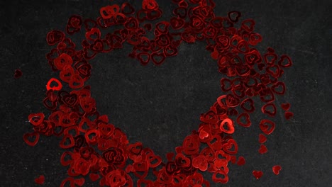confeti en forma de corazón en superficie negra en formación de corazón 4k