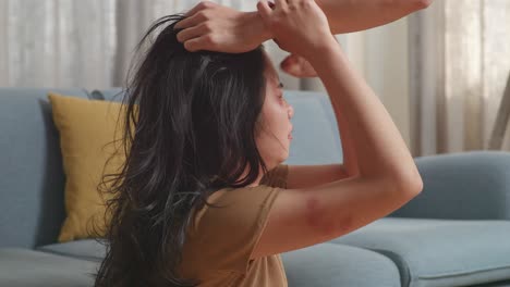 close up of young asian woman victim of violence with bruise on body abused by man's hands pulling her hair while being hit and shouted at home