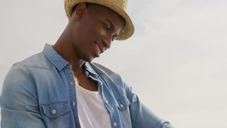 Vista-De-ángulo-Bajo-De-Un-Hombre-Afroamericano-Usando-Un-Reloj-Inteligente-En-La-Playa-4k