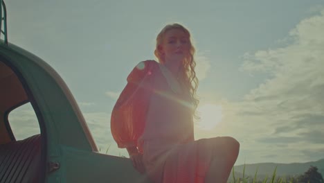 woman in vintage car at sunset