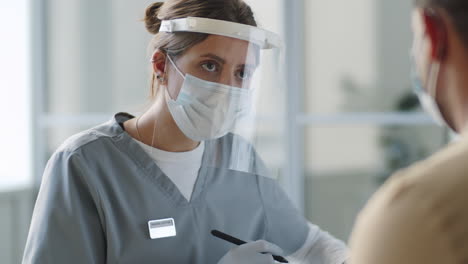 female doctor in protective uniform giving medical consultation