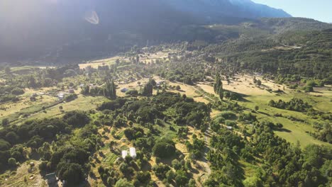 Pan-left-flying-above-El-Hoyo-valley-surrounded-by-a-beautiful-woodland-and-mountains-in-background,-Chubut,-Patagonia-Argentina