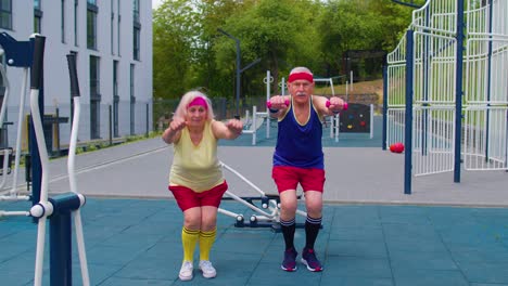 Senior-grandmother-and-grandfather-sports-team-doing-squatting-fitness-exercising-on-playground