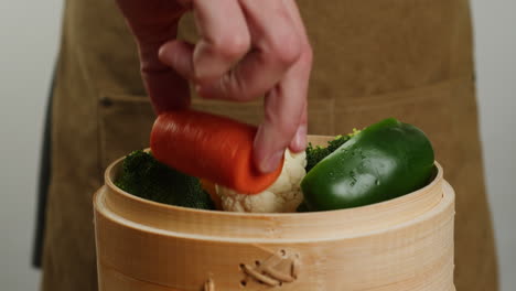 chef steaming vegetables in bamboo steamer