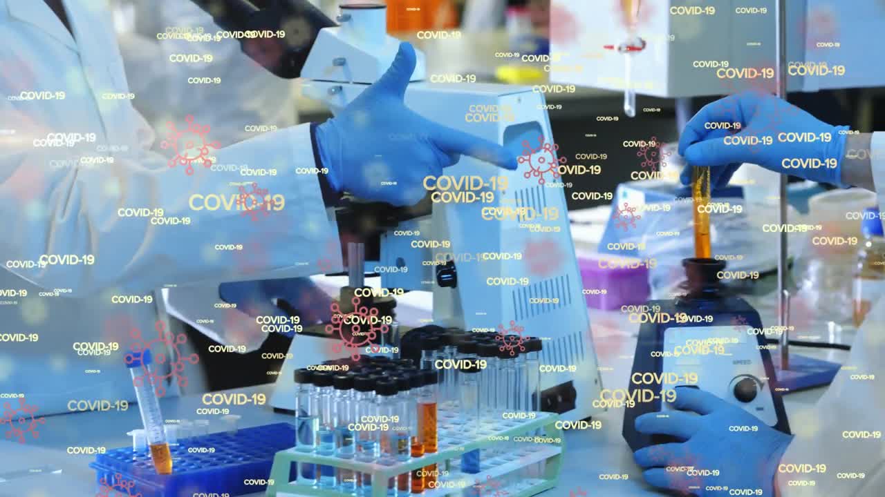 animación de palabras flotantes de covid-19 e iconos de células sobre un grupo de médicos