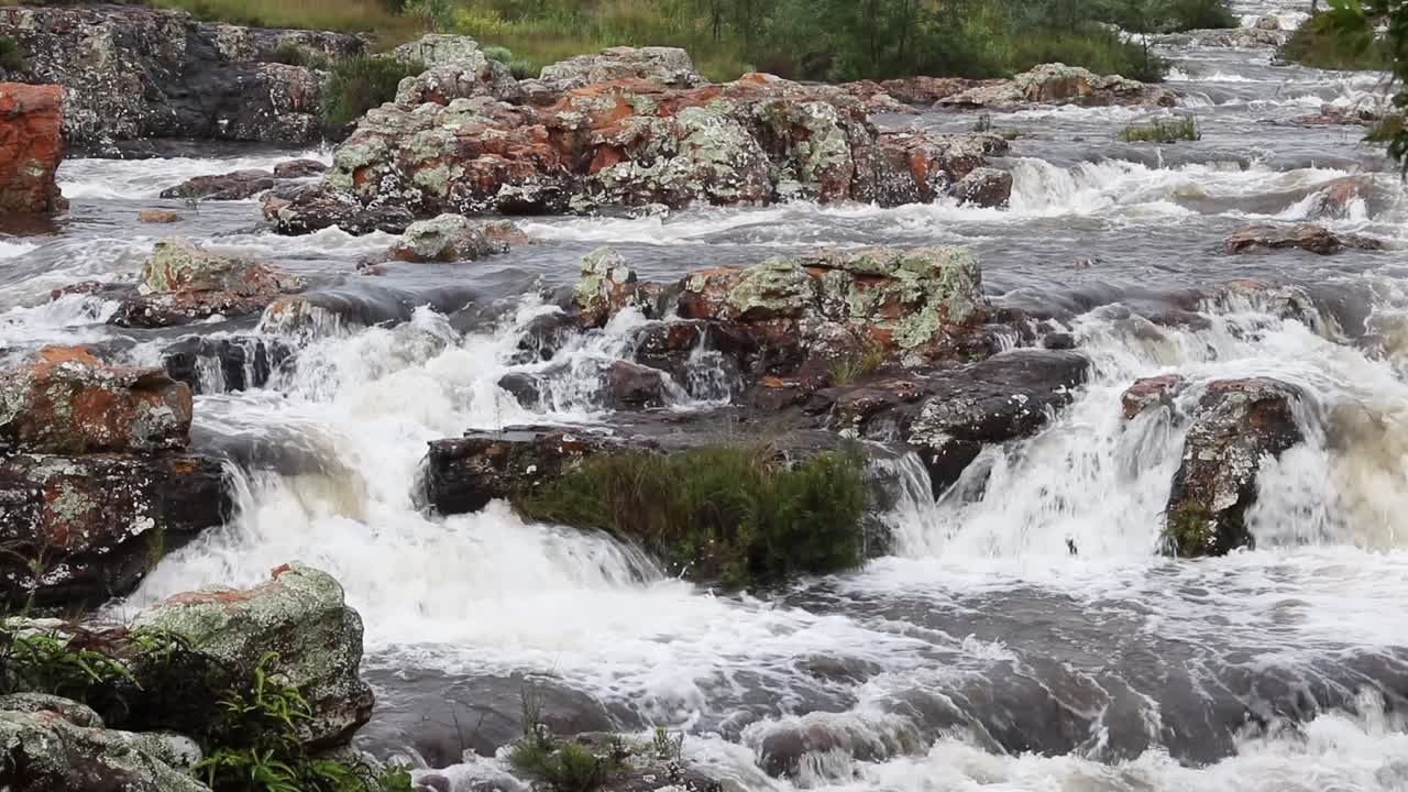 toma estática de agua blanca formándose mientras fluye sobre rocas
