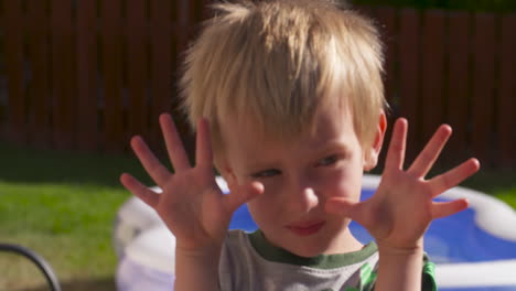 an adorable little blonde boy showing us his ten little fingers