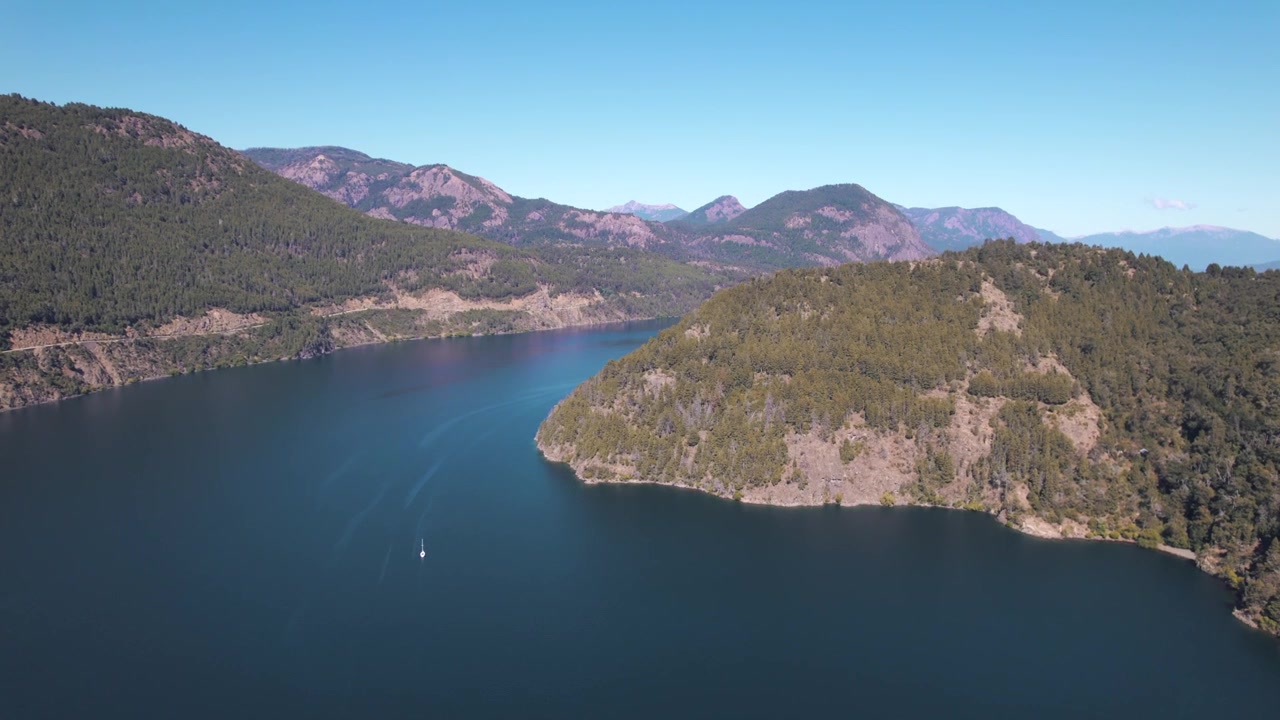 Vista aérea em 4K do Lago Lácar, perto de San Martín de los Andes, Neuquén, Argentina. Águas de azul profundo cercadas por exuberantes florestas patagônicas e verdes montanhas andinas