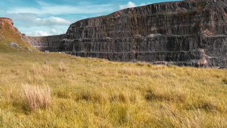 Enorme-Desfiladero-De-Piedra-Rodeado-De-Tierras-De-Cultivo-Con-Hierbas-Silvestres-Que-Soplan-En-El-Viento