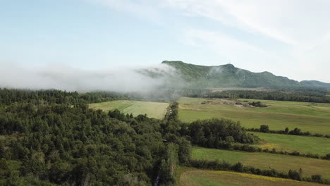 clouds overflowing a mountain on ridge of st-laurence river in gaspesie quebec canada
