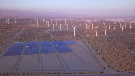 aerial view of a wind farm featuring wind turbines and solar panels in southern california - energy production