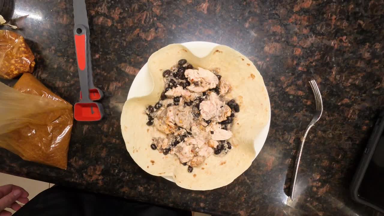 Close up view of a food vlogger hands demonstrating how to cook homemade tortilla wraps in a cozy home kitchen