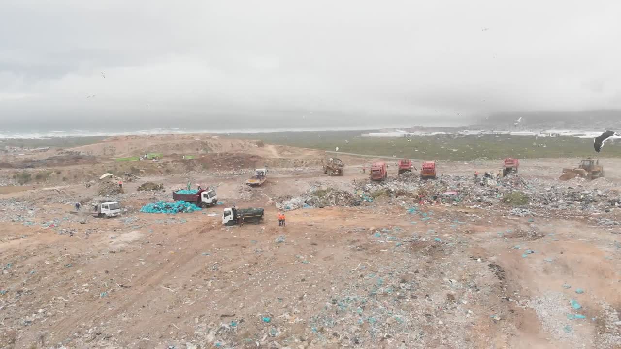 vehículos que limpian la basura apilada en un vertedero lleno de basura