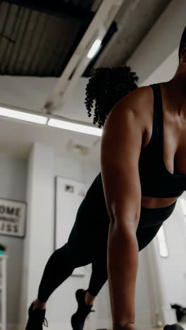 woman performing push-ups with dumbbells at home