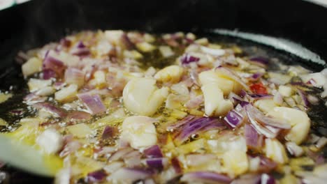 revolviendo la mezcla de vegetales fritos dentro de la sartén