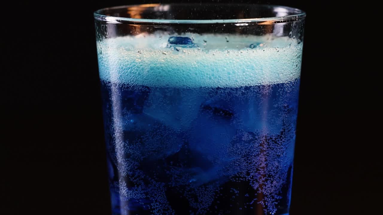 유리잔에 얼음이 들어있는 걱거리는 파란색 음료