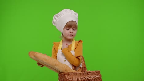 Child-girl-kid-dressed-as-professional-cook-chef-smiling-and-showing-basket-with-baguette-and-bread