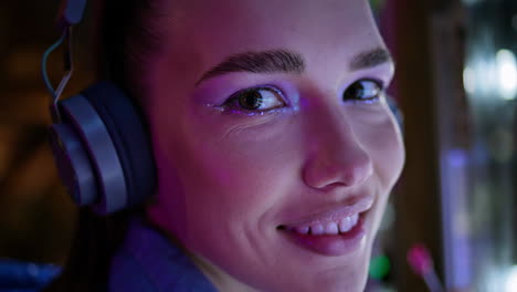 mujer moderna con maquillaje brillante mirando la cámara de cerca. retrato de una chica con auriculares.