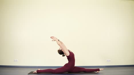 mujer joven y deportiva que se relaja después de un día estresante con la práctica de yoga, estirando los músculos y el núcleo.