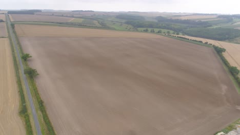 Imágenes-De-Drones-En-Un-Día-Nublado-A-Principios-De-Septiembre,-Panorámicas-Y-Movimientos-Que-Muestran-Los-Campos-De-Los-Agricultores,-El-Campo-En-General-Y-Una-Carretera-Larga-Y-Recta.