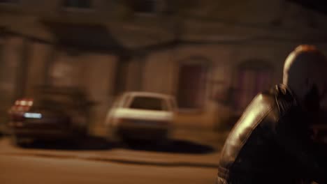side view of a brutal man riding fast his motocycle by night city street