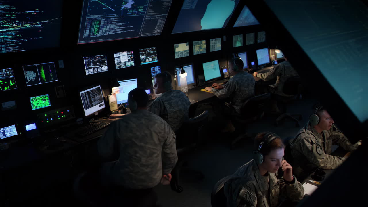 Military personnel working in a high-tech control room